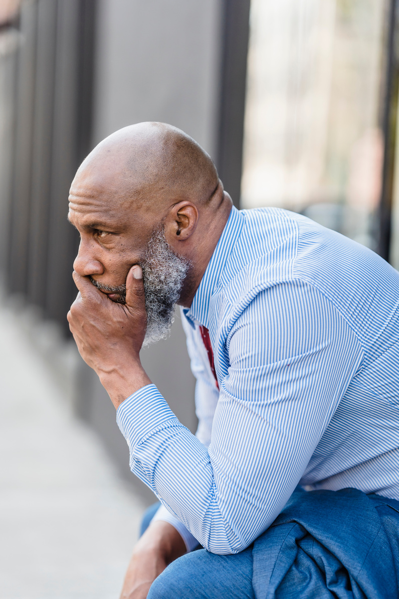Worried black worker on street